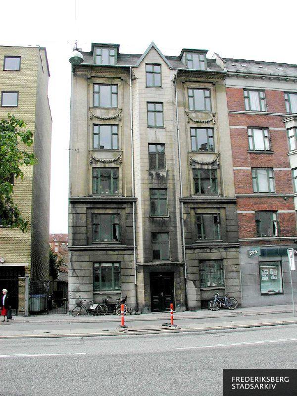 Borups Allé 115 med parkerede cykler op ad facaden og de gamle ejendomme side om side med nyere