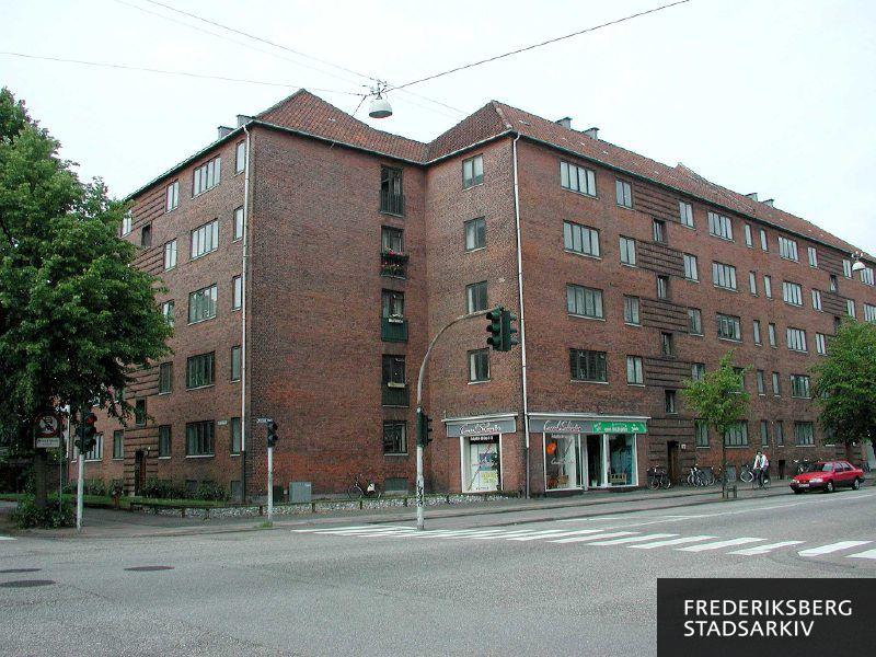 Facaderne Borups Allé 133-135 med Consol Solcenter og Fuglebakkevej 97 delvist skjult af træer