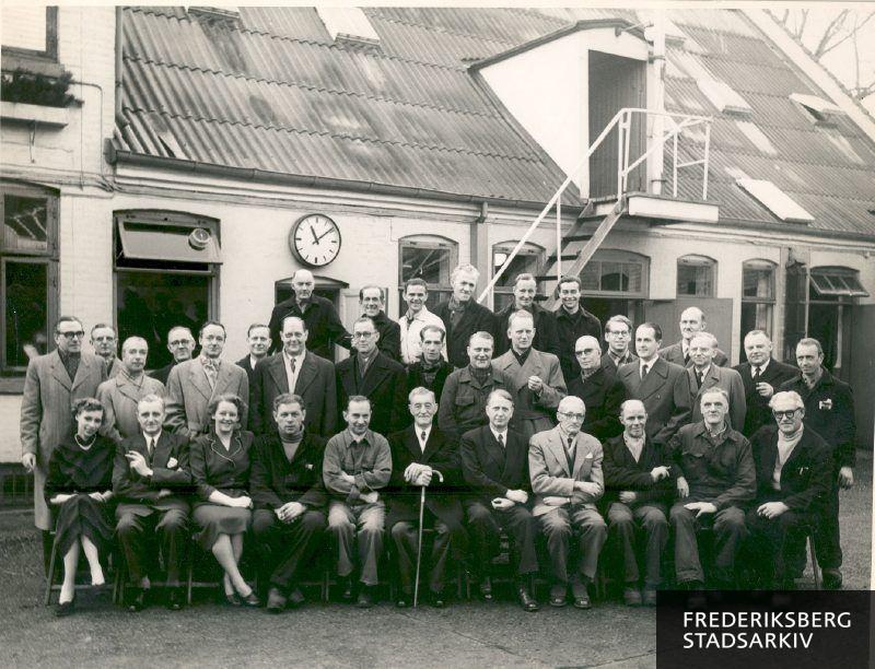 Udendørs personalefoto fra 1967 af Dansk Svovlsyre og Superphophat Fabrik A/S oprettet i 1903 - senere kendt som Superfos A/S. Lokaliteten var i 1967 Nyelandsvej 143 på Frederiksberg, men ejendommen blev senere delt og fik nye ejere.