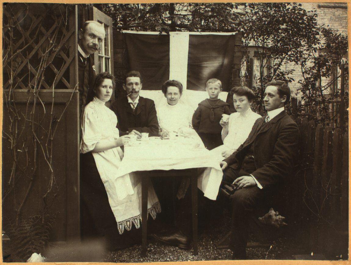 Familien Hansen og Oldenburg i en have i De Classenske Boliger. 

Senere tilkomne oplysninger: Det er sandsynligvis ikke Anna Nikoline Hansen på billedet men derimod Emil Nikolaus Hansens anden hustru, Maren Kirstine Camilla f. Frederiksen. Det menes, at Anna Nikoline Hansen døde i 1905