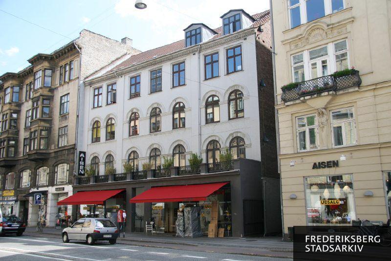 Ejendommen Gammel Kongevej 89 og 89A under udsalget i juli 2008. Der er røde, udtrukne markiser og sommerbeplantning på balkonen over møbelforretningen Aisen