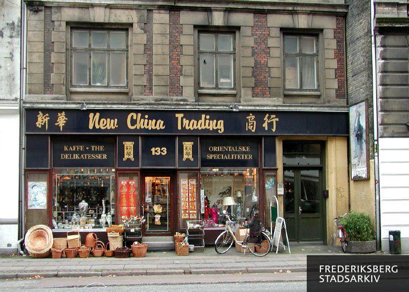 New China Trading har kinesiske specialiteter men nogle facadedetaljer stammer fra den tidligere butik, Sofus Lunds købmandsforretning. Fotografen har kategoriseret butiksfacaden som gammel og bevaringsværdig, New China Tradings forretning her er dog fra sidste halvdel af 1900-tallet