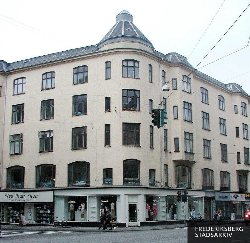 Facaden på hjørneejendommen Gammel Kongevej 85 med tårn og dametøjsbutikken Madam My på hjørnet, Andante og flere butiksfacader på Gammel Kongevej og New Hair Shop på Værnedamsvej 17