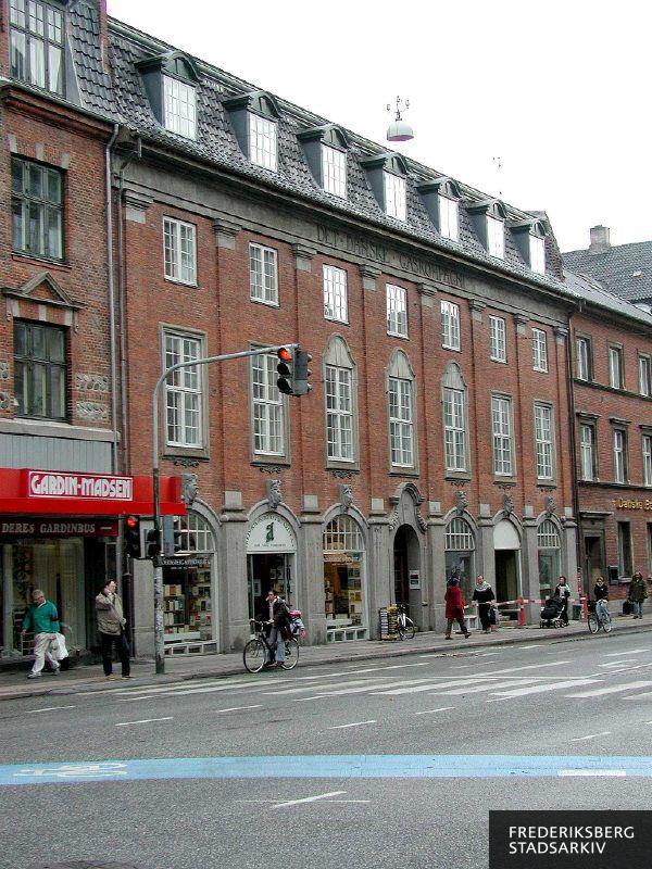 Ejendommen fra 1908 er tegnet af arkitekt Gottfred Tvede og noteret med bevaringsværdi 3 i Kulturarvstyrelsen, som fremhæver ejendommens nuancering af etagerne, skulpturelle dekorationer og fint svungne kviste. Her under ombygning af lokalerne, hvor det markante Frederiksberg Antikvariat havde været i årtier. Her ses lidt af naboejendommene