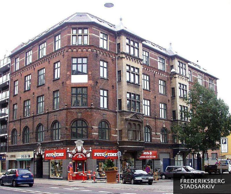 Hjørneejendommen Gammel Kongevej 153 og Edisonsvej med butiksfacader. Den har flest detaljer på Edisonsvej med karnapper, spir m.v.