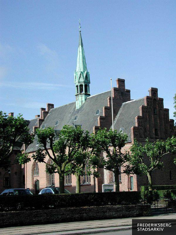 Emmauskirken med kamtakkede gavle, tagrytter og kobberspir. Kirken er tilknyttet og sammenbygget med Diakonissestiftelsens hovedbygning.
