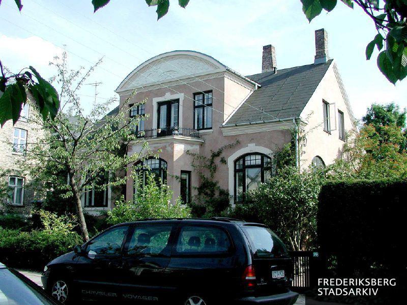 Villaen med frontispice, fronton og frontspids bag en parkeret bil i forgrunden i 2004