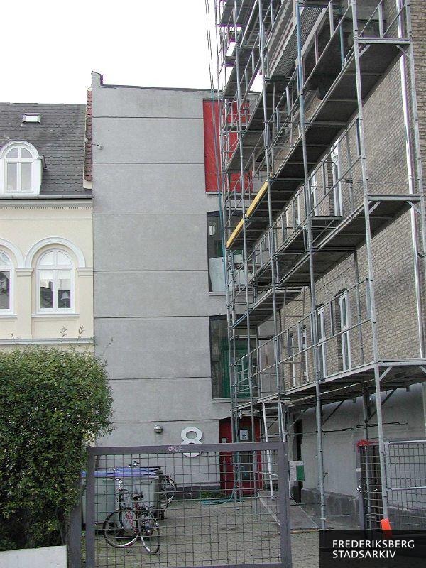 Indgangen til Lykkesholms Allé 8B ligger tilbagetrukket fra fortovet, her er der stillads på naboejendommen