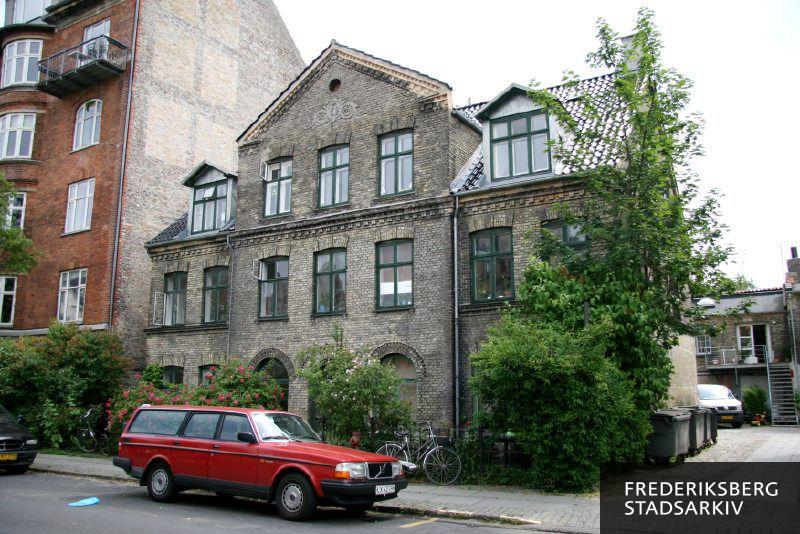Lykkesholms Allé 24-24A med en bil og en trehjulet cykel parkeret i gården ved nr. 24A i juni 2008