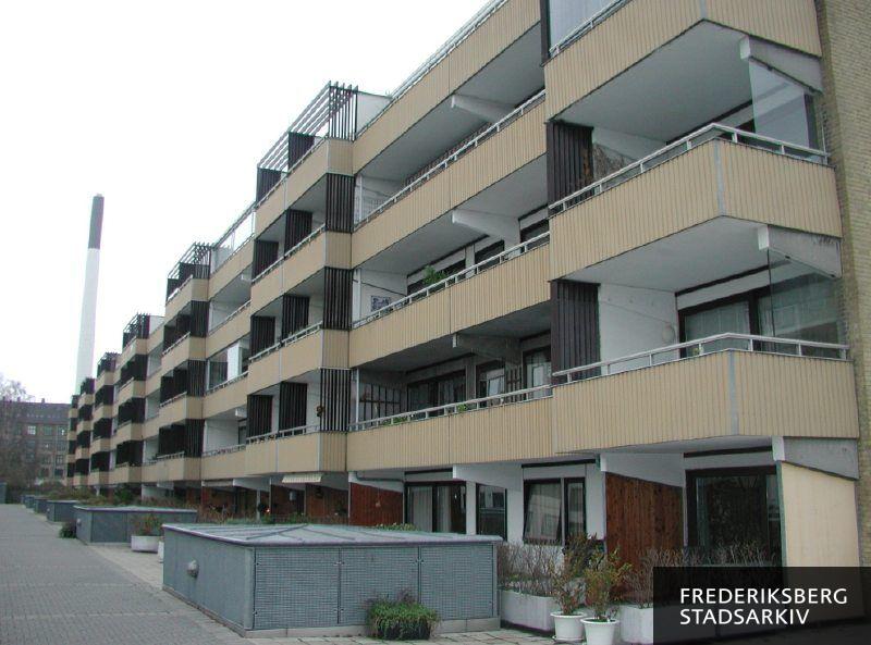 Altanfacaden til Lyøvej 14-24. Til venstre ses den 125 meter høje skorsten fra Frederiksberg Forsynings fire fjernvarmekedler bag etageejendomme på Nordre Fasanvej