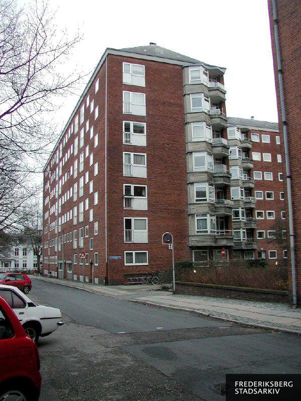 Maglekildevej 1-5 med altaner, desuden ses en advarselstavle om børn og stien til højre giver adgang til husnumre på Frederiksberg Allé. Til venstre ses en postkasse på hjørnet til Amicisvej og også lidt af Amicisvej 7-9.