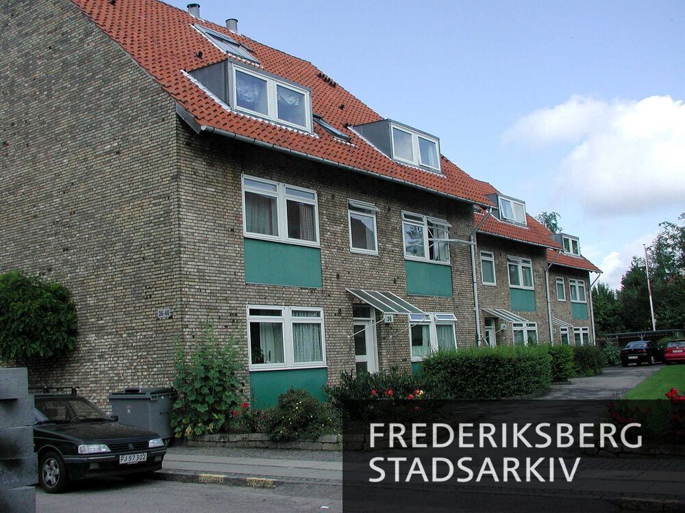 Stikvejen med nr. 36-40 med rosenbede ved indkørslen