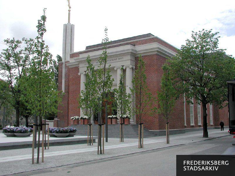 Jesu Kristi Kirke af Sidste Dages Hellige, The Church of Jesus Christ of Latter-day Saints, Copenhagen Denmark Temple. På fasciet står "Helliget Herren - Herrens Hus". Tårnet er 15 meter højt og fritstående, øverst står en forgyldt engel, der er  navngivet Moroni