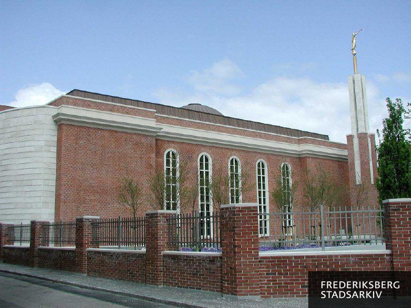 Jesu Kristi Kirke af Sidste Dages Hellige, The Church of Jesus Christ of Latter-day Saints, Copenhagen Denmark Temple. På fasciet står "Helliget Herren - Herrens Hus". Tårnet er 15 meter højt og fritstående, øverst står en forgyldt engel, der er  navngivet Moroni