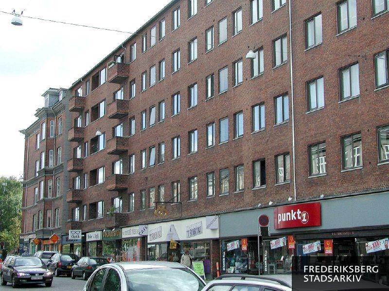 Hostrups Have Rolighedsvej 10 og naboejendommen med butikker i stueetagen som hvidevareforhandleren Punkt 1, Konditori Tribini, en brilleforretning og optiker, en blomsterhandel og et pizzeria. Der er udhængsskilte og lavskilte