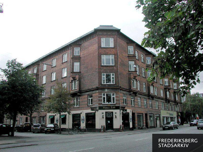 Rolighedsvej 18-20 og N.J. Fjords Allé 2-4 i 2006, i stueetagen ses Husar Pub, tomme butikslokaler og tøjbutikken Modehuset Carné