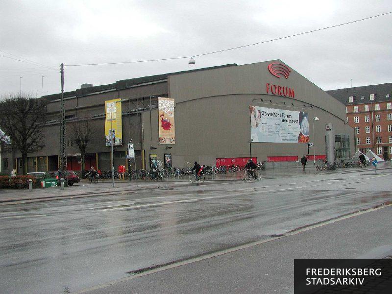 Forum en vinterdag i 2005 med plakater på facaden for Børnekultur Forum 2005, Bedre Bolig 2005 og Forums vinterprogram.
Foran Forum ses elevator, trappe, skilte m.v. til metrostation Forum