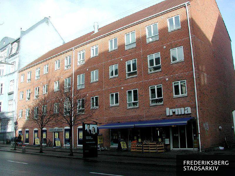 Ejendommen med supermarkedet Irma i stueetagen. Der skiltes for søndagsåbent, og foran ses en konservativ valgplakat til kommunalvalget i 2005