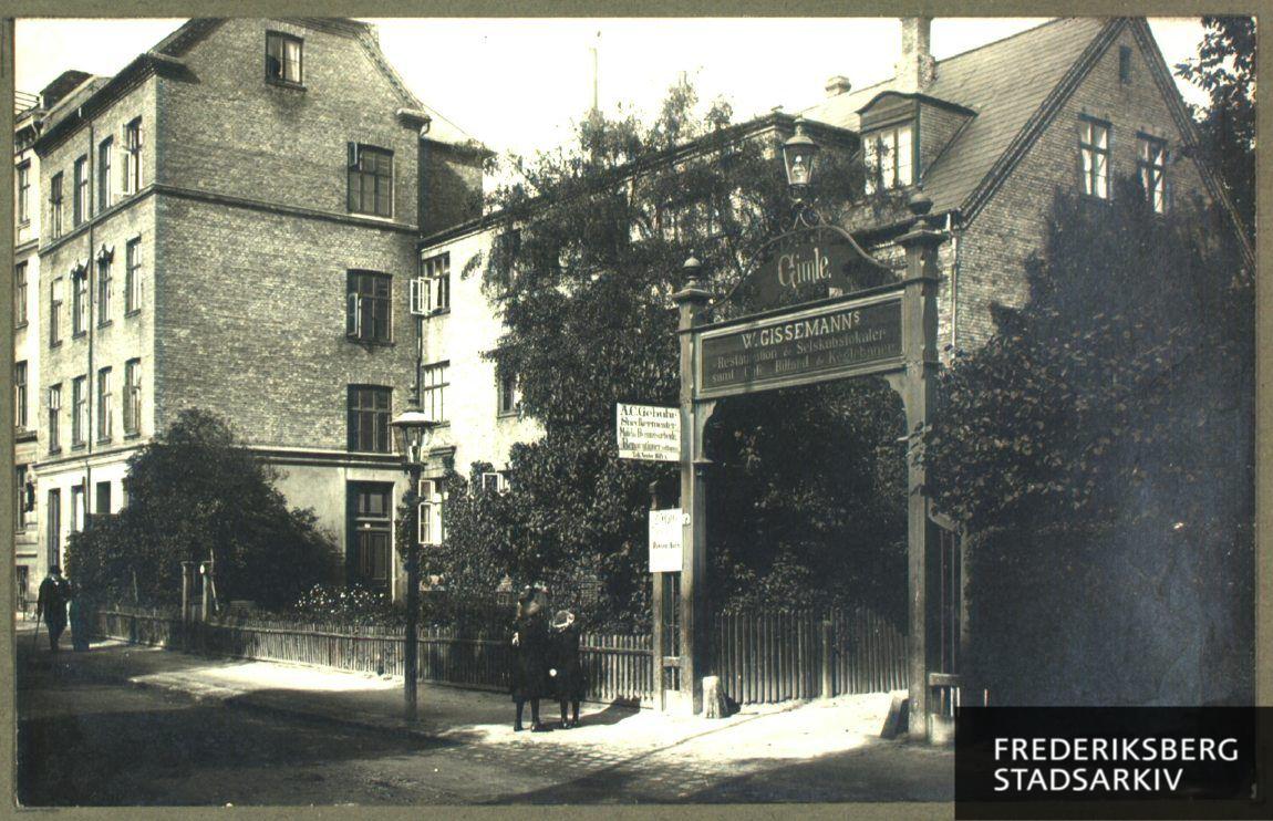 Indgangsporten til traktørstedet Gimle med skiltet 'W. Gissemanns Restauration og Selskabslokaler. Cafe, Billard og Keglebaner'