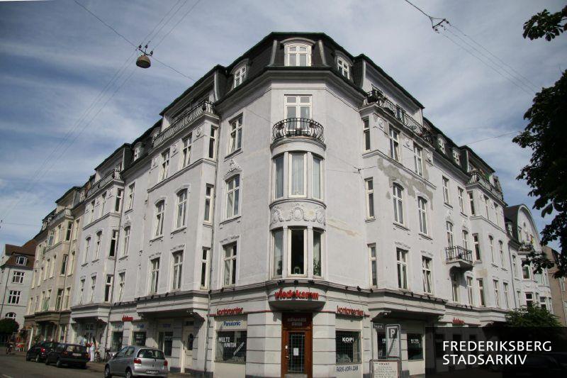 Hjørneejendommen Vodroffsvej 22-22A og Sveasvej 1 med hjørnekarnapper og altaner. Wiedekamm forhandler kontormaskiner i den store hjørneforretning. Husfacaderne mellem Sveasvej og Norsvej samt på Sveasvej ses her i juli 2008