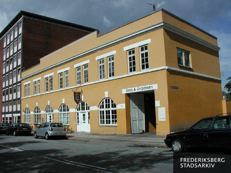 Erhvervsejendommen med udhængsskilt for malingproducent og farvehandler Beck & Jørgensen Farver og Lakker, som har kundecenter her. Til højre ses skilt for Pilateshouse