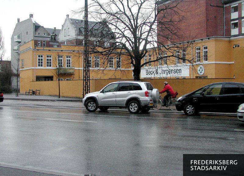 Erhvervsejendommene Vodroffsvej 61-33 med malingproducenten Beck & Jørgensens kundecenter forrest bag muren og Energiens torv med to bænke ud til Rosenørns Allé