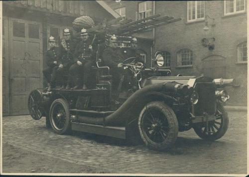 Brandfolk på motorsprøjte Dennis. Fra venstre ses brandmændene H. Nielsen, Niels Nielsen, Wilh. Jensen, chauffør Rasmussen og brandmand Bretved Hansen.