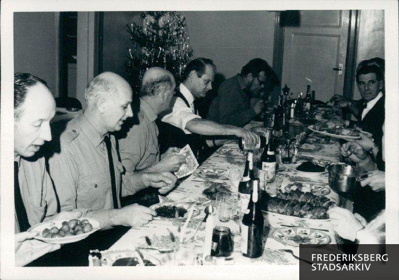 Julemaden er kommet på bordet og der øses flæskesteg og brunede kartofler. Juleaften på brandstationen ca. 1968.