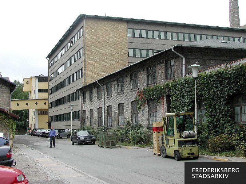 Gaden Porcelænshaven i Den Kongelige Porcelænsfabrik.
Forrest til højre Musselhuset, derefter det store L-bygningen og bagerst Råvaresiloen.