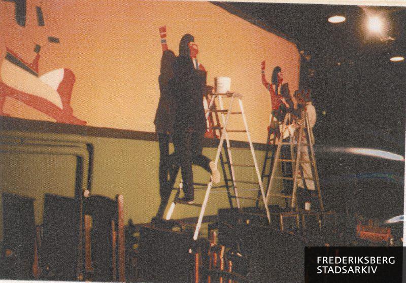 Teatersalens vægge dekoreres med ægyptiske vægmotiver til Riddersalens forestilling 'Cleopatra', der havde premiere den 21. februar 1984. De to dekoratører, der er trådt op på stigerne, er Bente og Signe Birkbøll