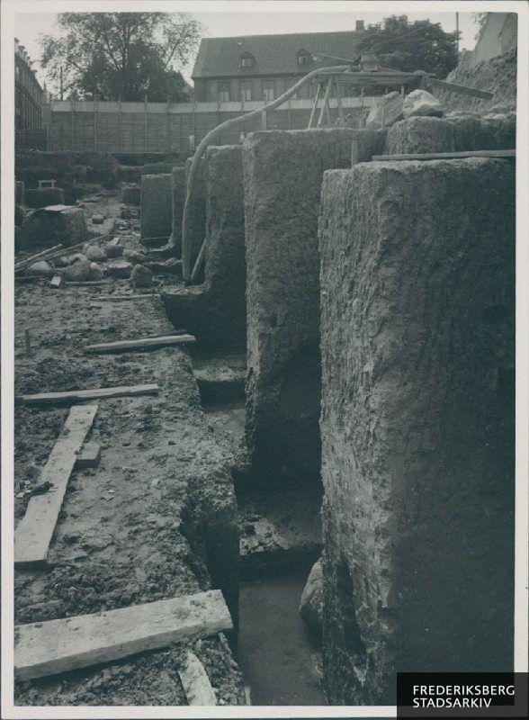 Byggepladsen i sensommeren 1942. Udgravning til kældre og fundament er i fuld gang i vestfløjen set ud for Frederiksberg Bredgade 11
