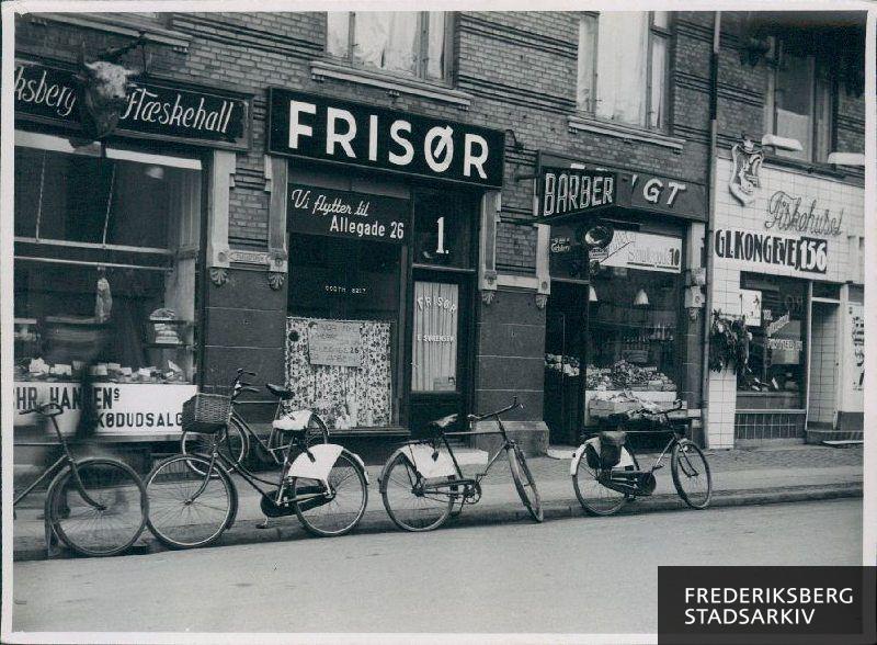 Forretninger i ejendommen Smallegade 1.
Fra venstre ses Chr. Hansens kødudsalg "Frederiksberg Flæskehall", en frisør og barber, en grønthandler og yderst til højre "Fiskehuset Femerling".
Frisøren skal flytte til Allégade 26, grønthandleren til Smallegade 10 og fiskehuset til Gl.Kongevej 156.
Udenfor forretningerne ses en række parkerede cykler.