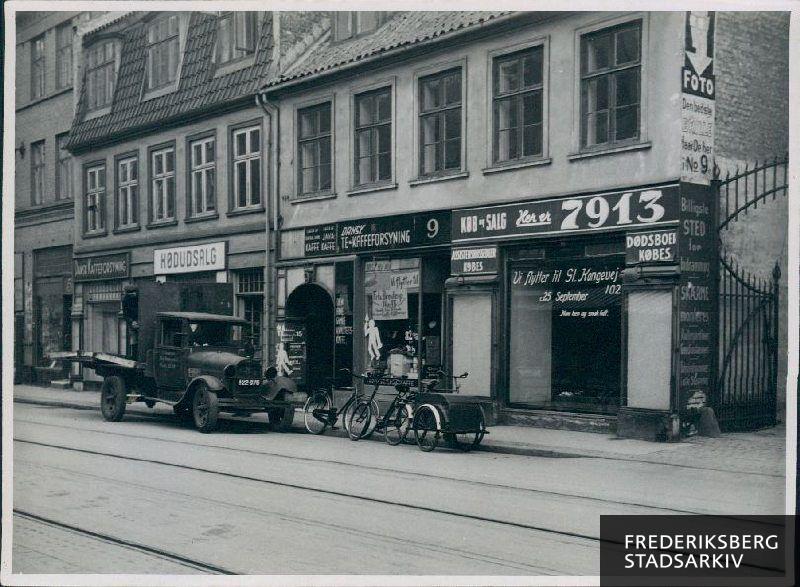 Ejendommene Smallegade 7 og 9. I nr. 7 ses den nedlagte butik "Dansk Kaffeforsyning" og en slagterbutik. I nr. 9 ses "Dansk Te og Kaffeforsyning" som skal flytte til Frederiksberg Bredegade 15 samt marskandiserbutikken "7913" som den 25. september skal flytte til Gl. Kongevej 102.
I gården til nr. 9 er en foto- og rammevirksomhed