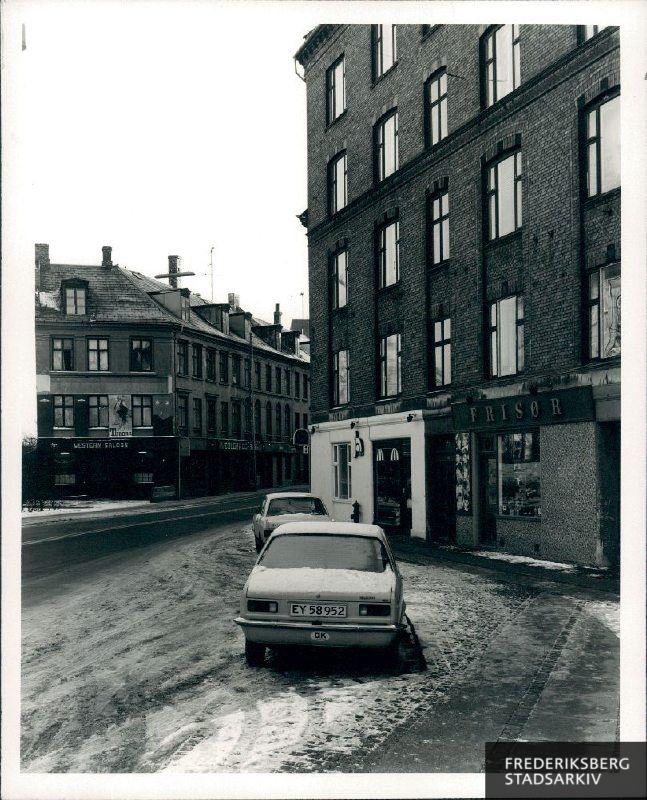 Bolig- og forretningsejendomme på Howitzvej set fra Nordre Fasanvej. Til venstre ses Howitzvej 72-74 med 'Vestcamp Saloon'. Ejendommen til højre med en frisørsalon i kælderen er Howitzvej 71