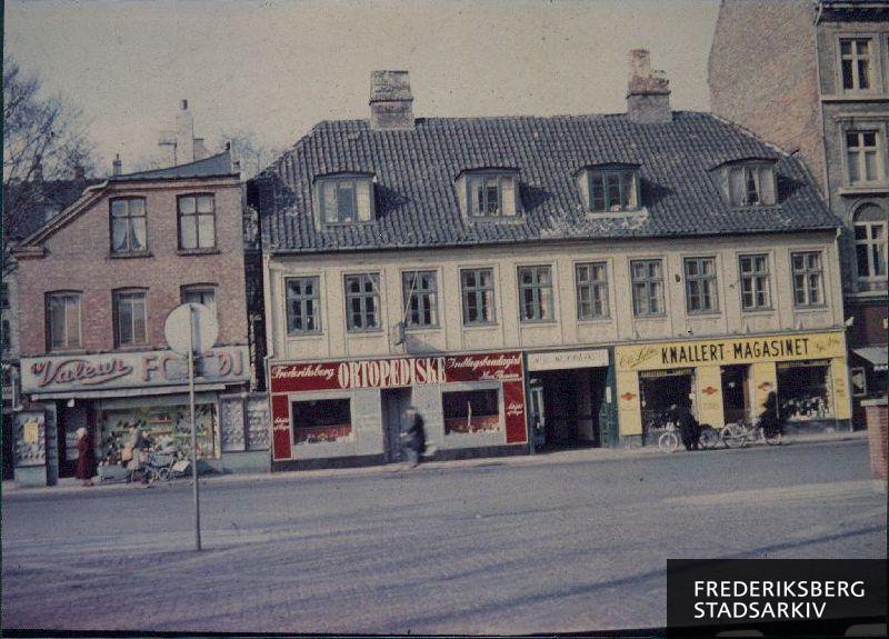 Huset på Smallegade18, hvor ortopædisk skomager Hans Thomsen havde butik, samt værksted i gården - fra 1939 til 1977. I højre side ses Per Høj Rasmussens forretning 'Knallert Magasinet'
