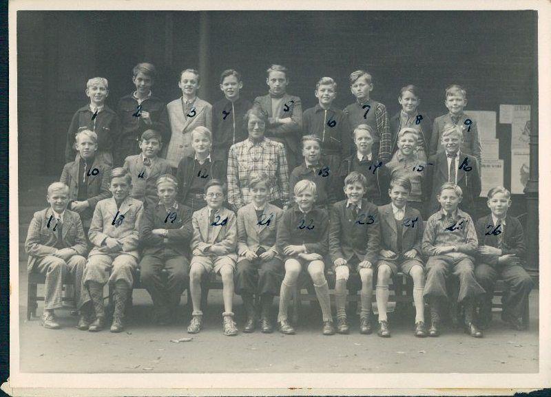 Elever fra 1.b på underskolen på Statsgymnasiet Schneekloths Skole. Bagerst fra venstre: Kjeld Albrechtsen, Hans Ole Nielsen, Erik Hansen, Allan Christensen, Erik Christensen, Svend Rasmussen, Hans Christensen, Vagn Frandsen og Frede Hansen. Midterste  række fra venstre: Svend Aage Christensen, Ib Olsen, Torben Cohn, klassens lærer Ilshøj, Erik kauffmann, Arne Holm, Erik Grünewaldt og Finn Gædeken. Forreste række fra venstre: Jørgen Bang, Stig halling Jørgensen, Freddi bjerring, Erik Nielsen, Torben Nayberg, Jens-Jacob Arnved, Mogens Bisgaard, James Clausen, Axel Jans og Alfred Huus