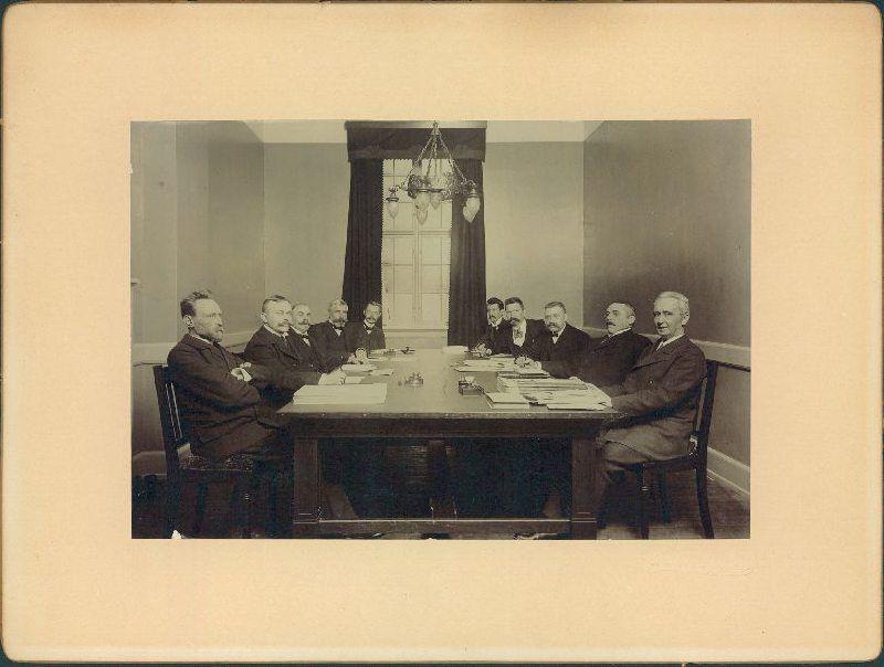 Frederiksberg Skatteråd ved mødet den 6/1-1908 i rådets forsamlingssal i Rådhuset på Howitzvej 2, stuen.
Personerne set fra venstre mod højre: 1) Kj.L. Müllen, direktør, cand.polyt./formand,  2) V. Gandil, Birkefuldmægtig, cand.polyt./næstfmd, 3) O.C.F.Gottschalksen