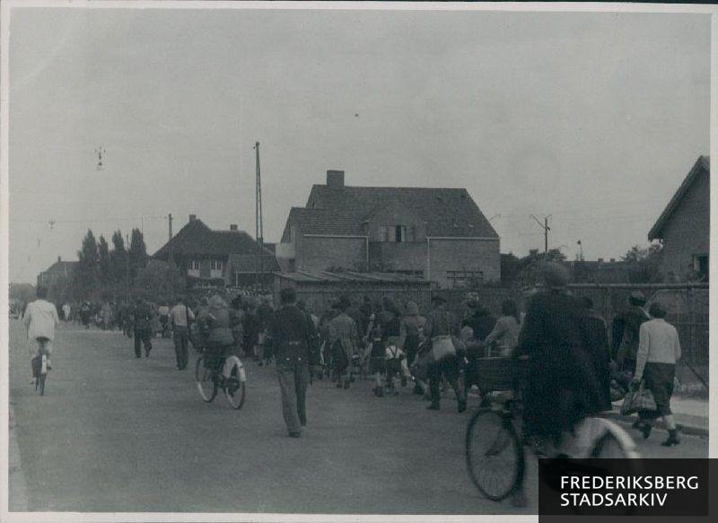 Tyske flygtninge forlader ad Hoffmeyersvej i retning mod Peter Bangs Vej Søndermarkskolen, hvor de har opholdt sig siden marts 1945, da den tyske besættelsesmagt okkuperede skolen til brug for indkvartering af flygtninge.  Skolens interniør og klasseværelser var efterladt i en sørgelig tilstand