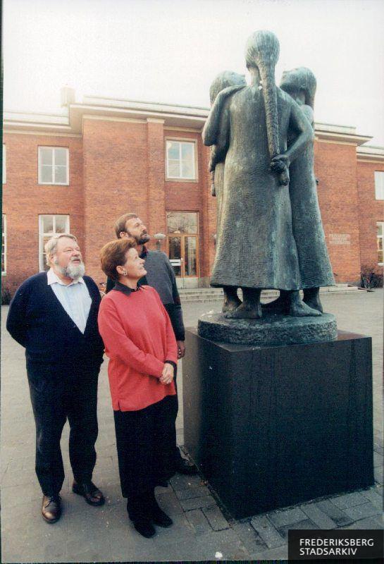 Tre medlemmer af Historisk-Topografisk Selskab for Frederiksberg står og kigger på skulpturen  "Tre søstre"  foran Frederiksberg Hovedbibliotek. Det er fra venstre Jørgen Fisker, Allan Tønnesen og Anne Møller-Rasmussen