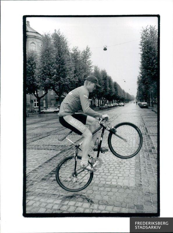 Rasmus Dige, cykelbud hos firmaet "Den blå kurér".  Han er lige vendt hjem fra Hamburg, hvor han har deltaget i Eurpamesterskab for cykelbude. Rasmus Dige er fotograferet på Frederiksberg Allé ved Sankt Thomas plads, hvor han viser nogle af sine evner på cykel. Han vandt titlen "Eurpamester i sprint for cykelbude"