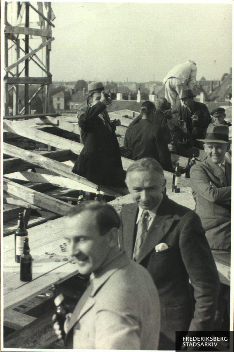 Rejsegilde på én af de tre moderne industribygninger, som blev opført på Paul Bergsøes fabriksgrund på Bülowsvej i årene 1935-39. På billedet ses håndværkere, ansatte og gæster. Receptionen blev holdt på bygningens tagkonstruktion