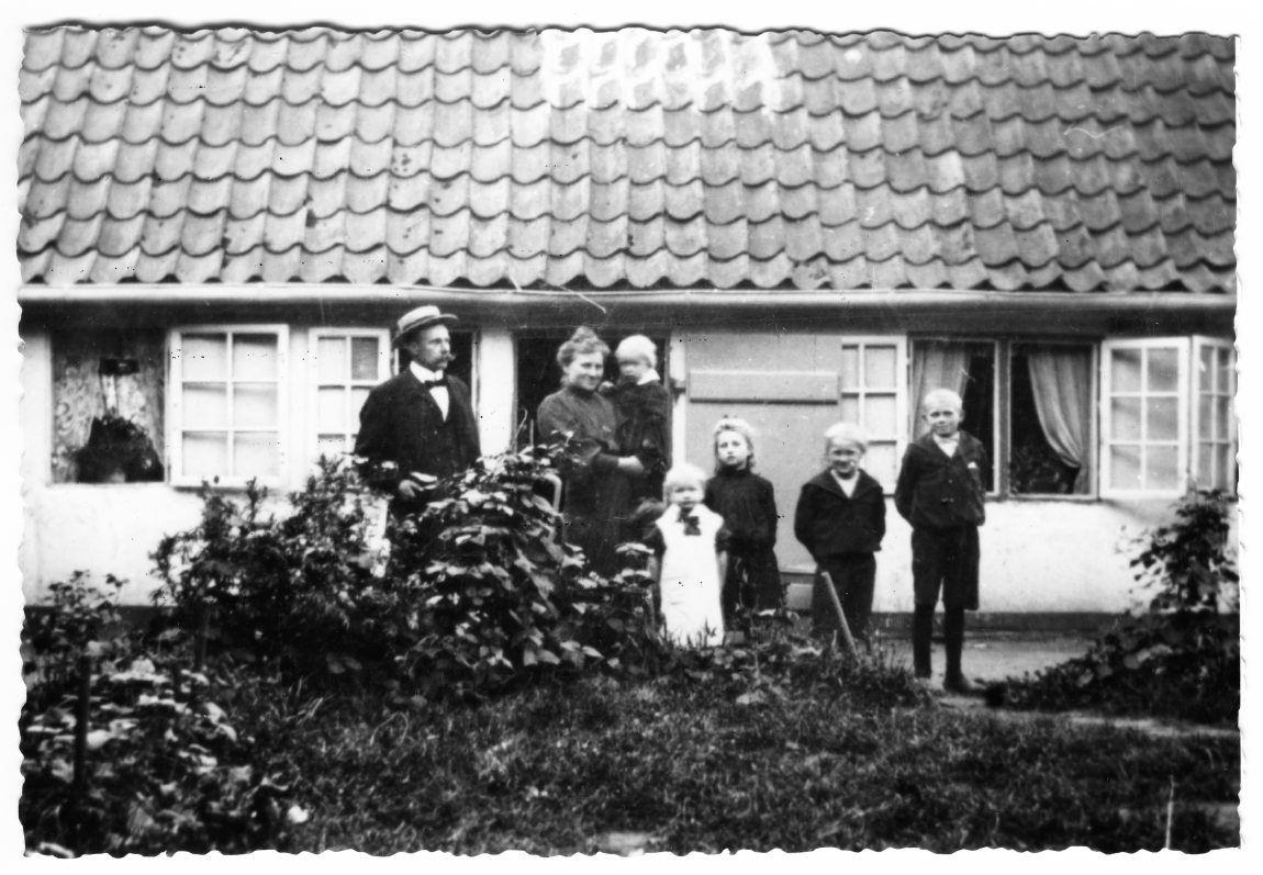 Slotsbetjent Hans Peter Christoffersen og hans hustru Karen Alfrida fotograferet sammen med deres børn foran slotsbetjentboligen