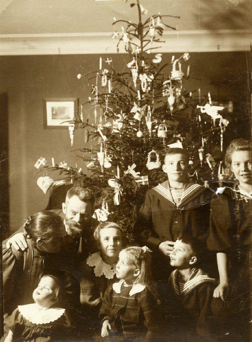 Far og mor med deres børn omkring et juletræ