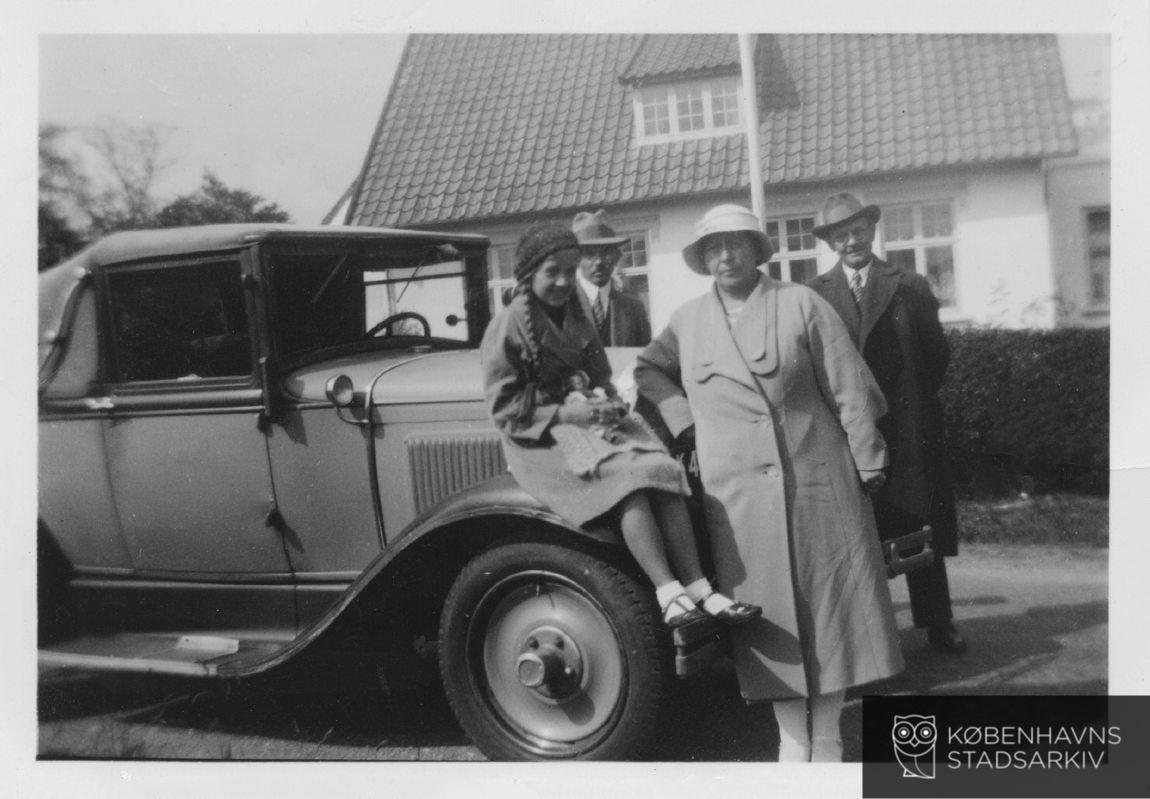 Familie foran bil