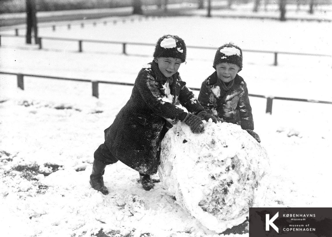 To børn ruller en snebold