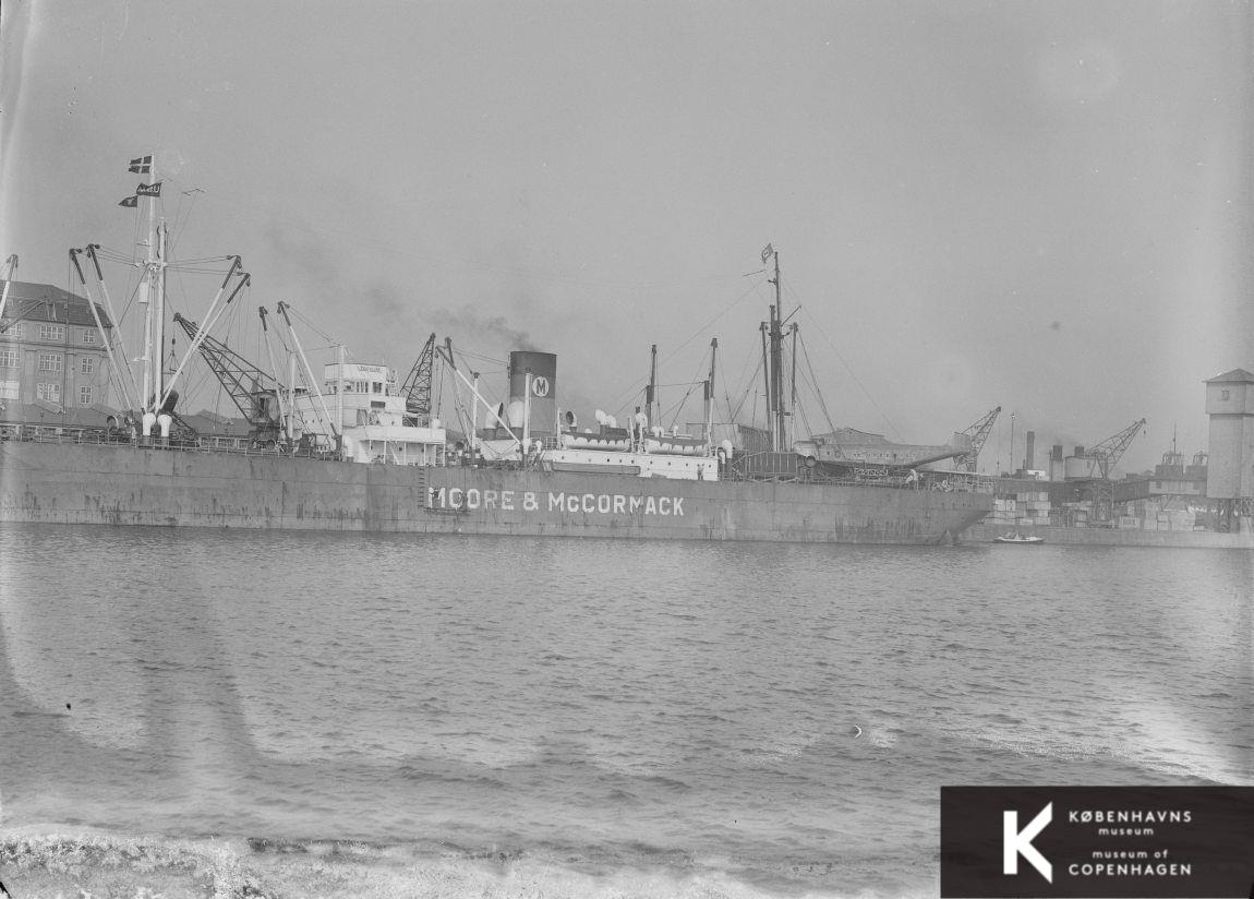 Skib fra Moore & McGormack ved Frihavnens Vestkaj: fragtskib, dampskib, skibsmast, havnekran, havneområde, redningsbåd, fartøj, bolværk, Martin 156 Super Clipper, februar 1938