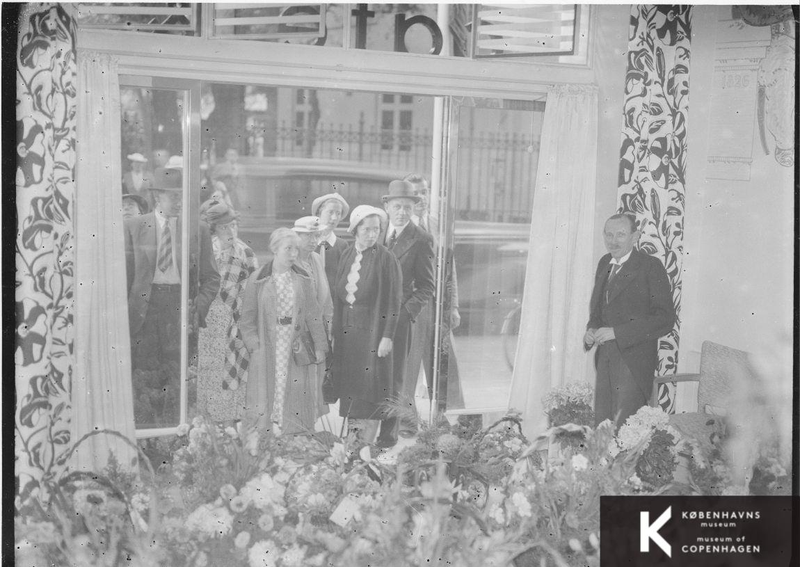 Personer ser på blomster gennem en rude